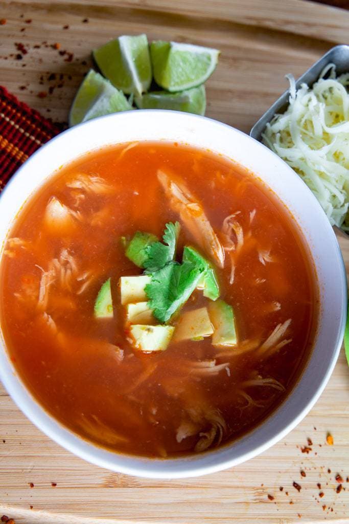 sopa azteca with avocado pieces and melted cheese