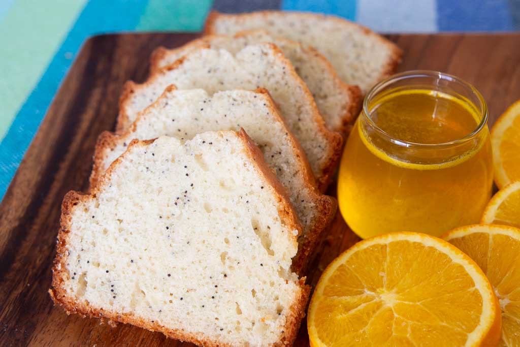 Close up of sliced poppy seed bread with orange glaze.