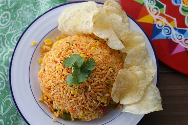 Portion of Costa Rican arroz con pollo served with cilantro sprigs on top.