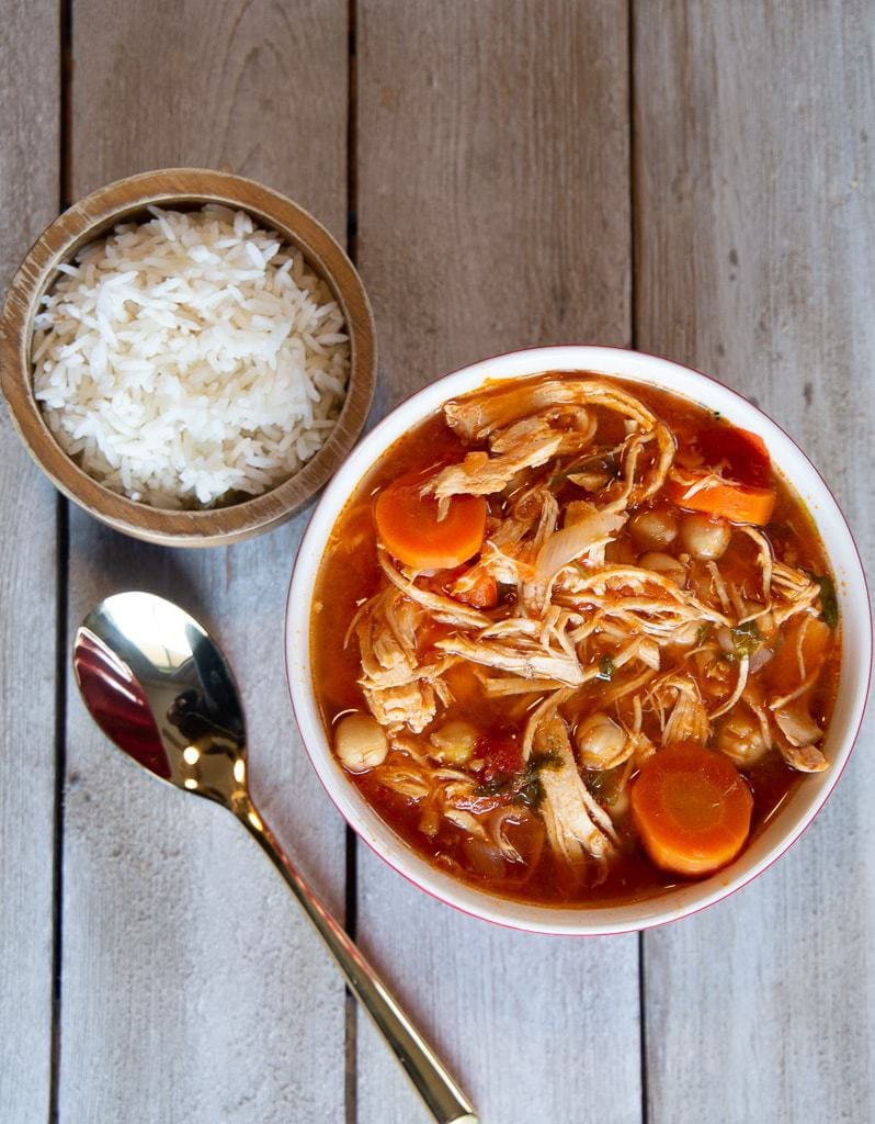 costa rican garbanzo soup with chicken and tomato, spoon, and cooked white rice