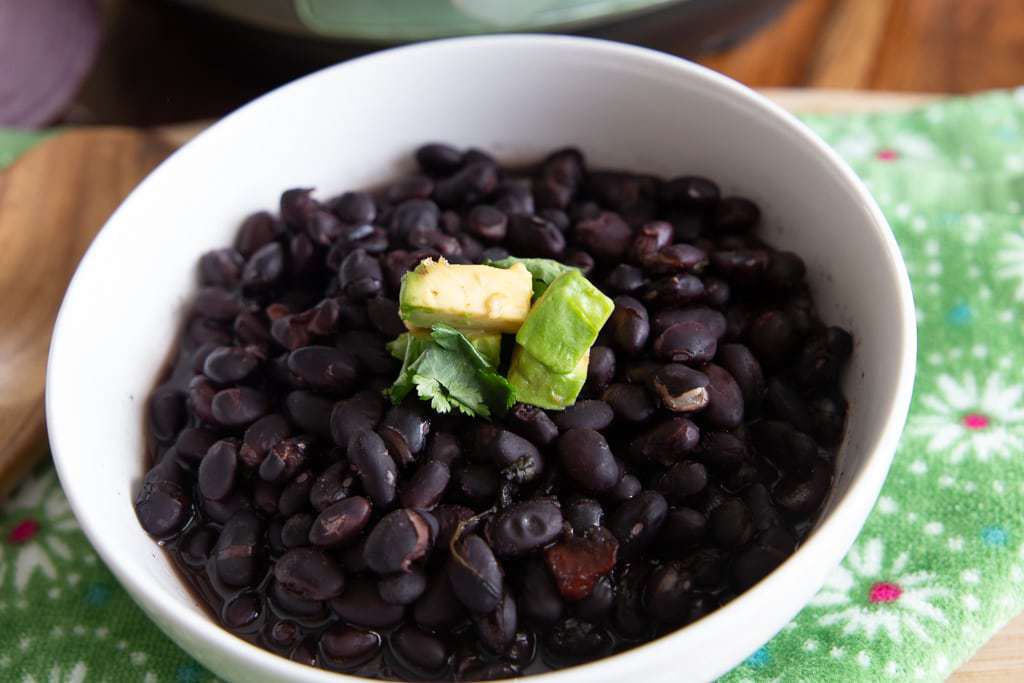 cooked black beans with avocado garnish