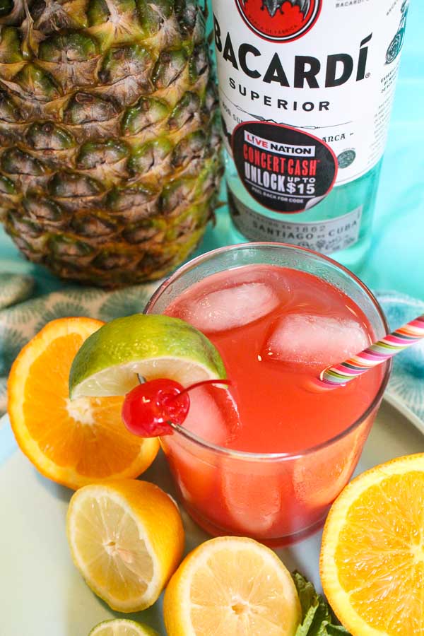 rum punch cocktail in glass with paper straw