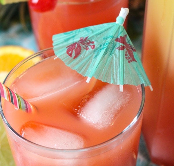 Rum punch cocktail in glass with ice and umbrella.