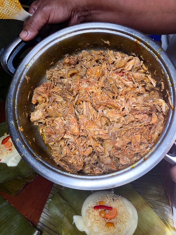 Man holding pot of shredded pork in Costa Rica.