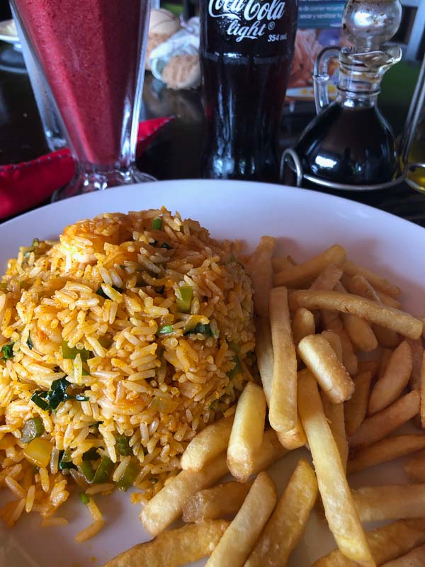 plate of arroz con pollo with french fries and diet coke at soda la parada la fortuna