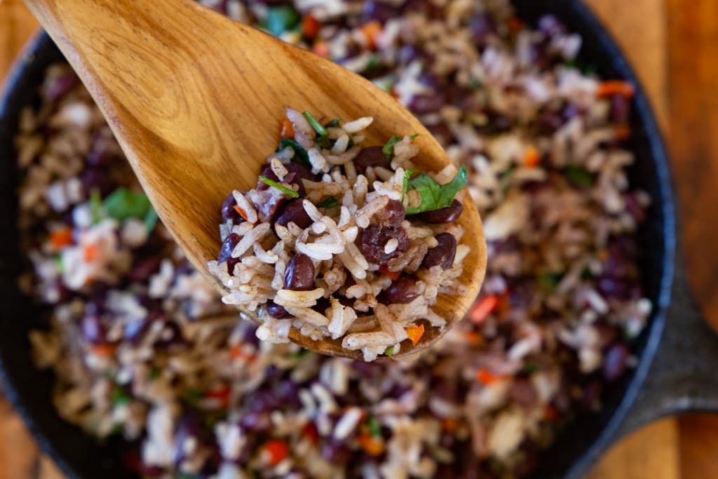 wooden spoonful of gallo pinto above bowl costa rican food