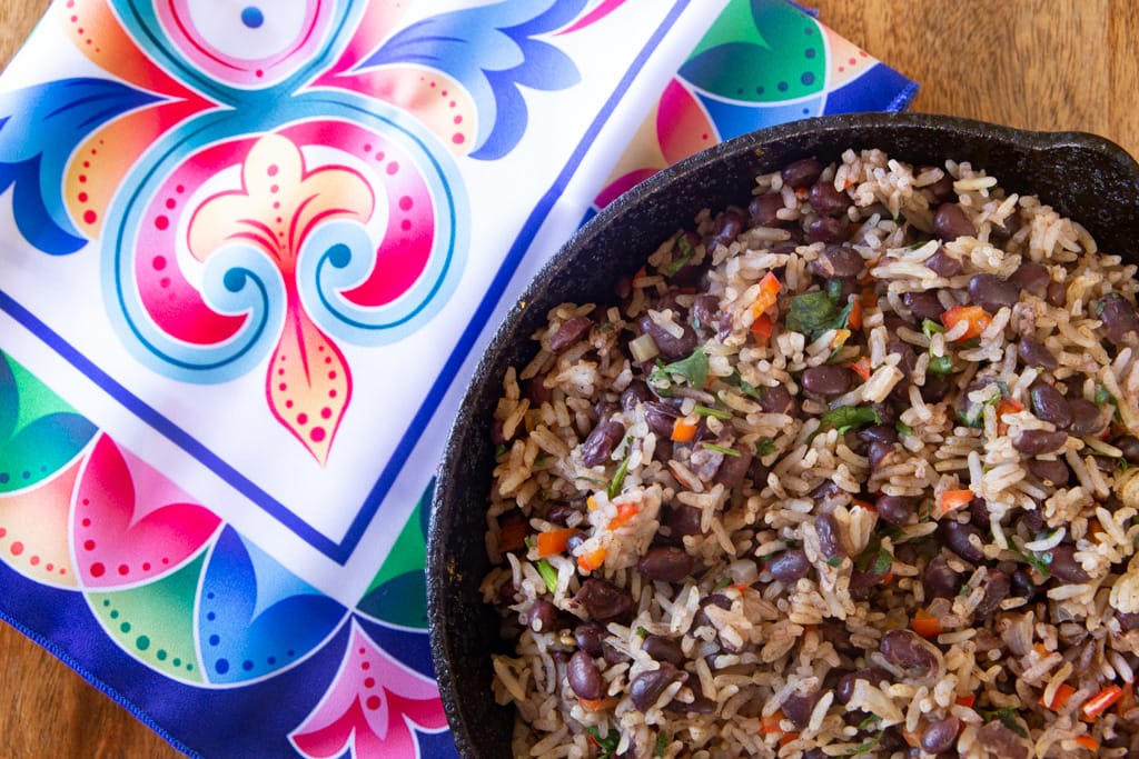 costa rican gallo pinto in black bowl accompanied by brightly colored napkin