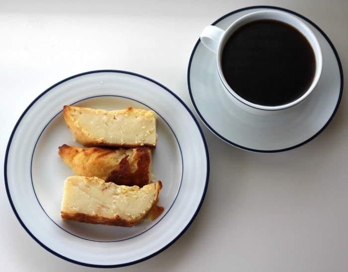 tamal ed masa and side of coffee on white and blue plates.