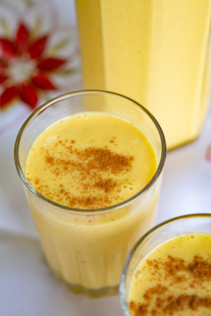 glasses of costa rican egg nog with poinsettia in background.