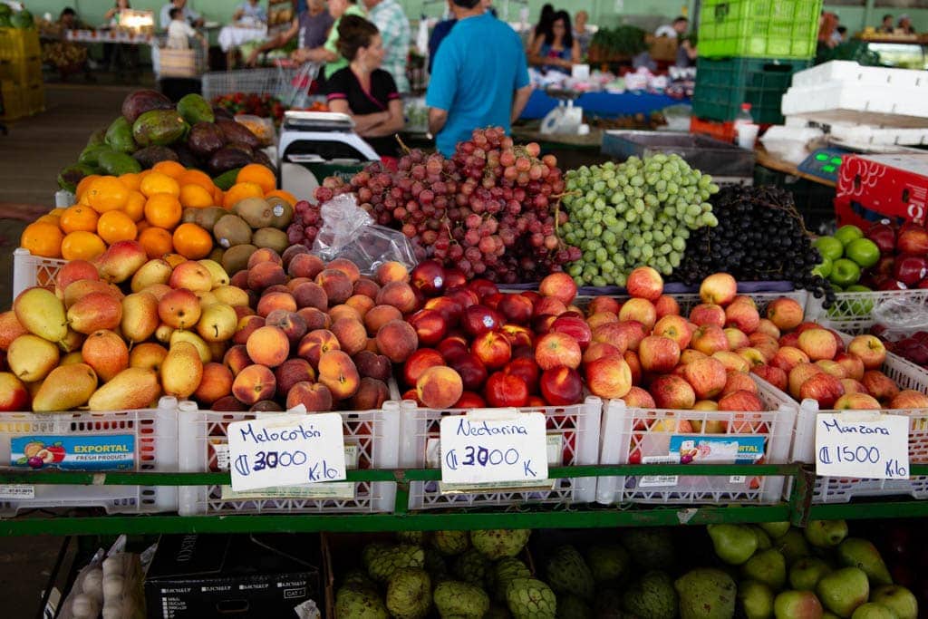 fresh fruit stand in costa rica with people in background.