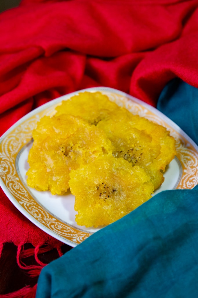 costa rican plantains- patacones on a plate with red and blue napkins