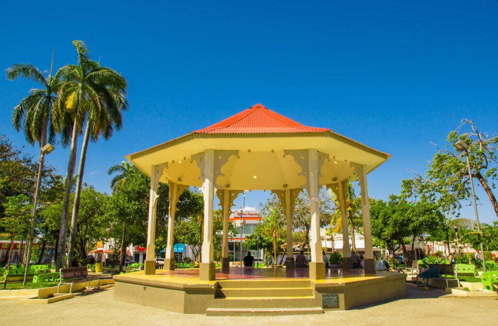 Outdoor view of people resting inside of a building in the middle of the park in Liberia Guanacaste Costa Rica in gorgeous blue sky in summer day.